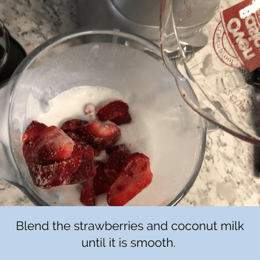 frozen strawberries being added to the blender