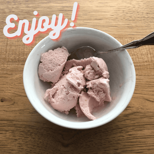 dairy free strawberry ice cream in a white bowl with a spoon