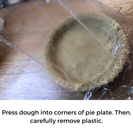 Gently lift plastic wrap off pie dough in pie pan.