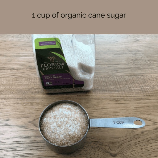 1 cup of organic cane sugar in a measuring cup on a wooden countertop